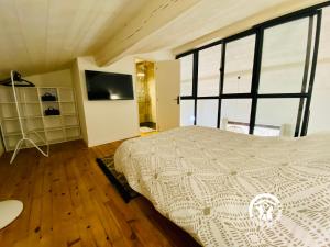 a bedroom with a bed and a flat screen tv at Loft cocon climatisé - Imprenable vue sur le château Comtal in Carcassonne