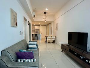 Il comprend un salon doté d'un canapé et d'une télévision à écran plat. dans l'établissement Utopian Homes at Sutera Avenue, à Kota Kinabalu