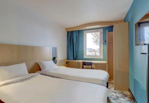 モンリュソンにあるB&B HOTEL Montluçon Centreのベッド2台と窓が備わるホテルルームです。
