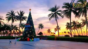 Un árbol de Navidad en una plaza con palmeras en Kalia Hotel, en Phu Quoc
