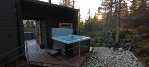 ein kleines Bad mit einer Badewanne auf einer Holzterrasse in der Unterkunft Villa Sudenkolo with outdoor jacuzzi and log sauna in Syöte