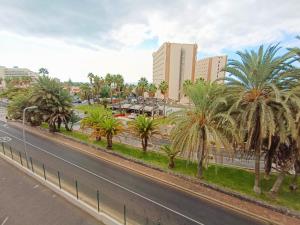 a street with palm trees in front of a city at Apartment La Fiesta in Arona