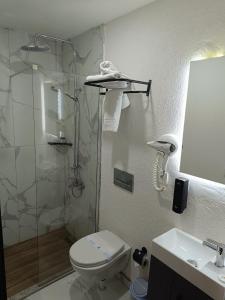 ein Bad mit einer Dusche, einem WC und einem Waschbecken in der Unterkunft Comfy Otel Antalya Lara in Antalya