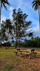 a picnic table in a park with palm trees at RUMAH TAMU TEPI PANTAI in Dungun