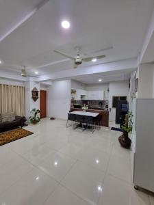 a large living room with a table and a kitchen at Three Bed Attached Bath Netflix Wifi Smart TV Parking Near Airport in Islamabad