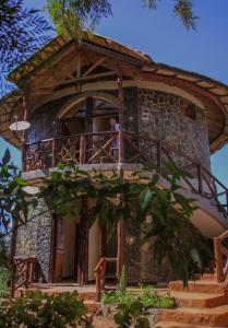 un hombre parado en el balcón de una casa en Lalibela Hidmo Cozy Place en Lalibela