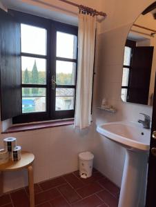 La salle de bains est pourvue d'un lavabo et d'une fenêtre. dans l'établissement Fattoria Agriturismo Nerbona, à Casole dʼElsa