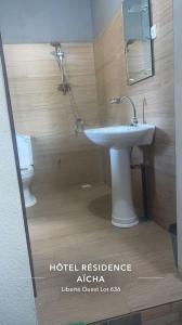a bathroom with a white sink and a toilet at Hôtel Résidence Aïcha Tambacounda in Tambacounda