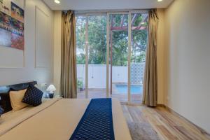 a bedroom with a large bed and a large window at Eternal wave by HappyInch in Calangute +100 photos