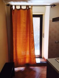 カターニアにあるAppartamento Giadaの窓付きのバスルーム(オレンジ色のカーテン付)