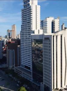 um edifício branco alto numa grande cidade em Mundial Hotel & Flat SSA em Salvador