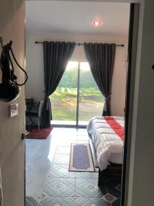 ein Schlafzimmer mit einem Bett und einem großen Fenster in der Unterkunft ที่พักฮิมฝายบึงกาฬ 
