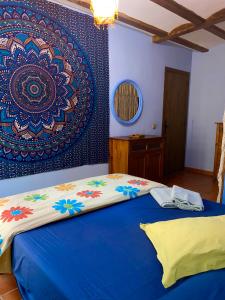 a bedroom with a bed and a wall with a painting at Cuatro Rosas Jerica in Jérica