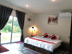 um quarto com uma cama e uma grande janela em ที่พักฮิมฝายบึงกาฬ 
