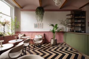 a restaurant with pink walls and chairs and tables at NEWLY OPENED - Parklane Hotel in Amsterdam