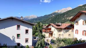 a view of houses in a village in the mountains at Hotel Nès Crépes in Pozza di Fassa