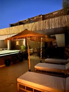 een patio met een parasol en een tafel en stoelen bij Riad Belharra in Marrakesh