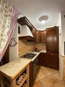uma cozinha com armários de madeira e um forno com placa de fogão em Pietracamela em Pietracamela