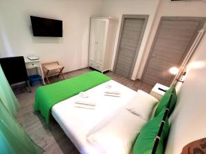 a bedroom with a green and white bed and a television at Rossetti Rooms in Trieste