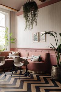 un soggiorno con divano, tavolo e sedie di NEWLY OPENED - Parklane Hotel ad Amsterdam