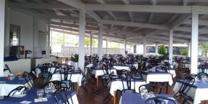 a room filled with tables and chairs with blue and white tablecloths at Villaggio La Feluca in Isca sullo Ionio