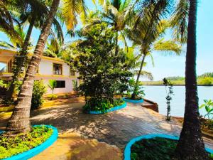 ein Resort mit Palmen und einem Wasserkörper in der Unterkunft RiverKiss Villa in Canacona