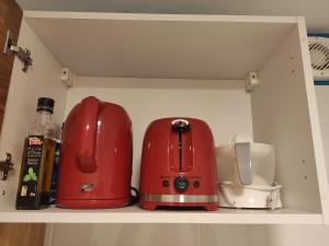 una cocina con dos electrodomésticos rojos en un estante en Studio spacieux aux portes de la Camargue en Beauvoisin