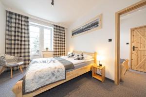 a bedroom with a wooden bed and a window at Pokoje Janosik in Zakopane