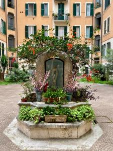 une statue devant un bâtiment fleuri dans l'établissement Giò House - Palazzo Storico, à Rome