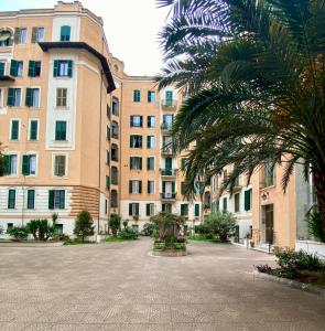 un grand bâtiment avec un palmier en face dans l'établissement Giò House - Palazzo Storico, à Rome