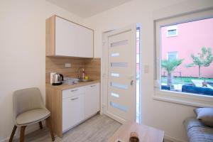 a kitchen with a table and a chair and a window at Sultan Apartments in Mostar