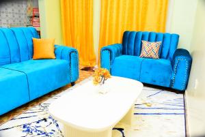 2 blaue Sofas und ein Couchtisch im Wohnzimmer in der Unterkunft Royalty Homes in Nairobi