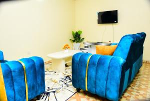 a living room with two blue chairs and a table at Royalty Homes in Nairobi
