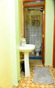 ein Bad mit einem Waschbecken und einem WC in der Unterkunft Royalty Homes in Nairobi