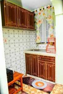 a kitchen with wooden cabinets and a window and a table at Royalty Homes in Nairobi