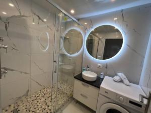 a bathroom with a shower and a washing machine at Golden seconds in Strasbourg