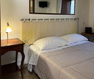 a bedroom with a bed with a table and a mirror at Residenza Le Ginestre in Bovino