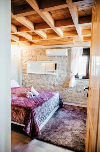 a small room with a bed and a stone wall at Villa Pialia 