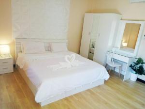 a bedroom with a white bed with a white bow on it at เรือนไทย 1 in Ban Don Klang