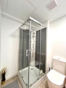 a glass shower in a bathroom with a toilet at Titanic Dreams in Madrid