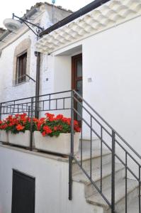 un edificio blanco con 2 cajas de flores en un balcón en Residenza Le Ginestre en Bovino