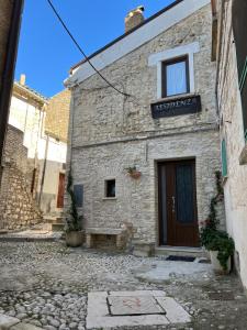 a stone building with a door on a street at Residenza Le Ginestre in Bovino