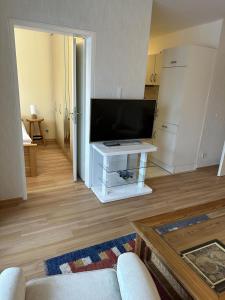 ダンプにあるFerienwohnung Küstenzauberのリビングルーム(薄型テレビ、テーブル付)