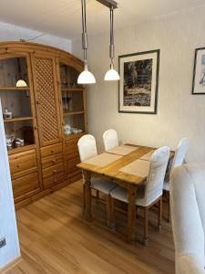 ダンプにあるFerienwohnung Küstenzauberの木製のテーブルと白い椅子のあるダイニングルーム