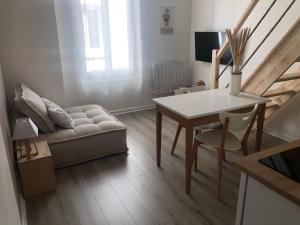 a living room with a table and a couch at Appartements coeur de ville de Vichy in Vichy