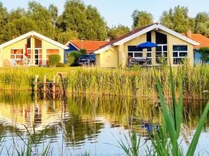 dom z jeziorem przed nim w obiekcie 6 person holiday home in Otterndorf w mieście Otterndorf