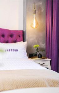 キーウにあるFreedom apartments in city centerの- ベッドルーム1室(紫色のヘッドボード付きの白いベッド1台付)