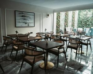 um grupo de mesas e cadeiras numa sala em City Hotel by Waves em Kenitra