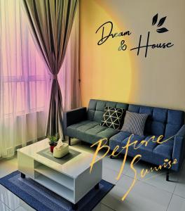 uma sala de estar com um sofá azul e uma mesa em Melaka AmberCove Homely Seaview 2R2B em Malaca