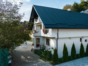 una casa blanca con techo negro en Pensiunea Marinela, en Sighetu Marmaţiei